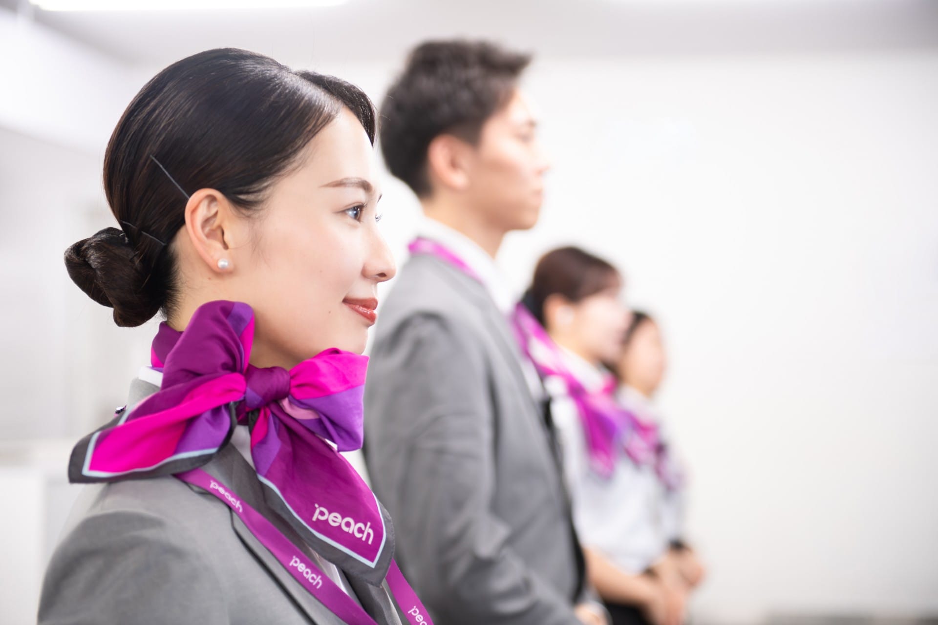 制服を着て並んでいるPeachの空港スタッフの写真